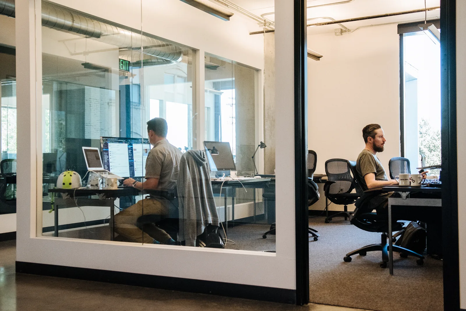 Members working in a glass-walled private office