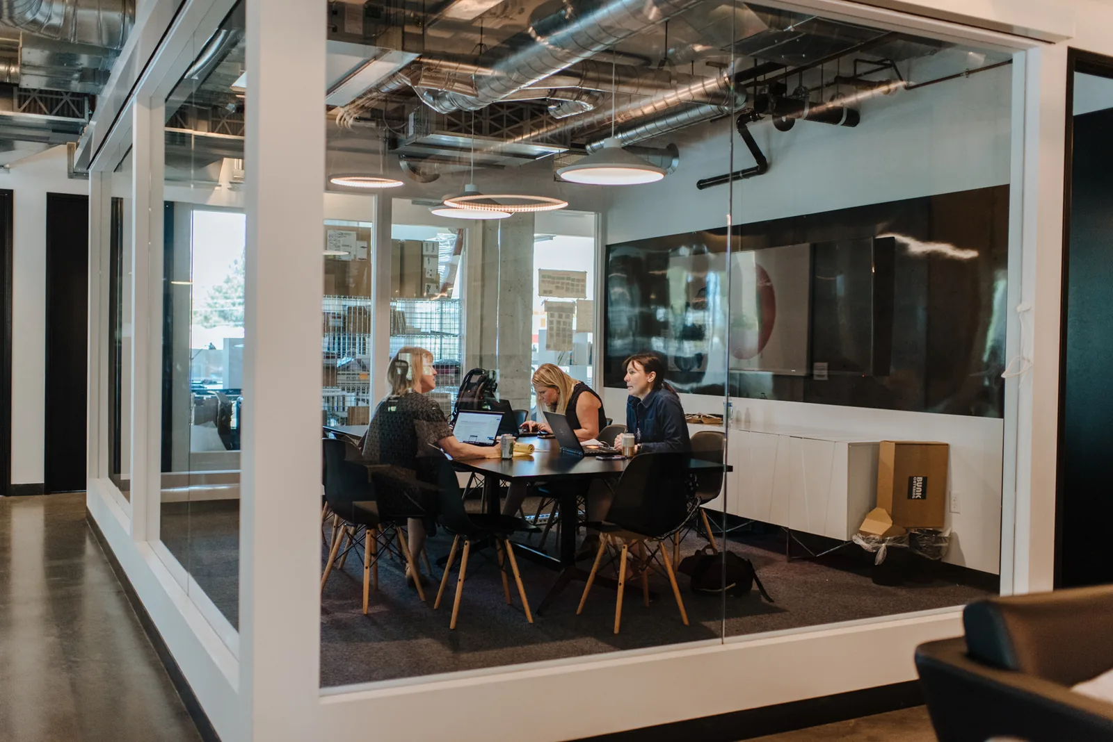 A team meeting in a glass-walled conference room at CENTRL Office