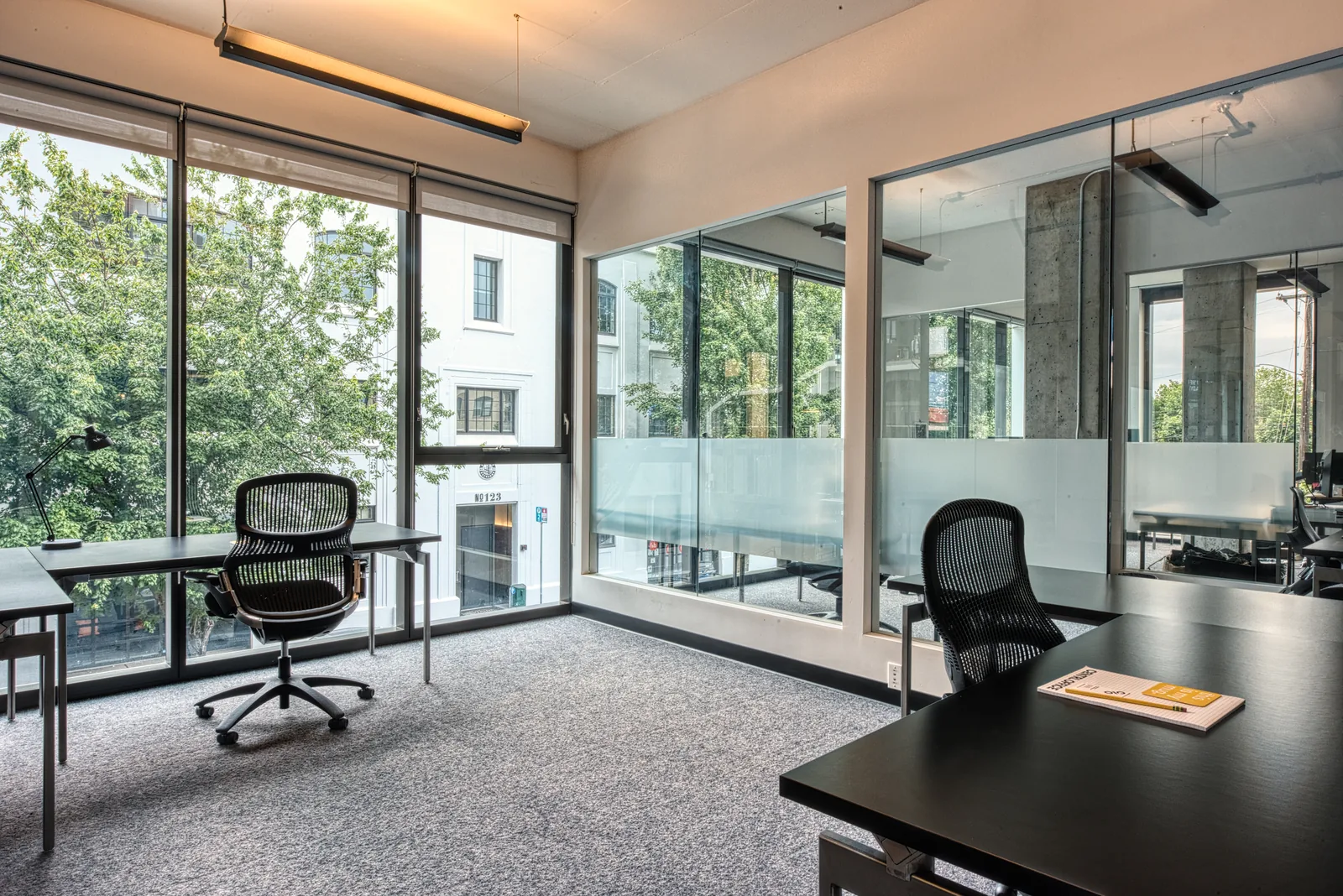 A private office with a desk and street views
